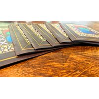 Close up of a set of closed copies of the zines on a wood table.
