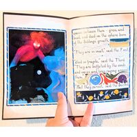 Photo of an open copy of the zine. The right page is text with marginalia on it and the left page is a full-page illustration with one of the figures blocked out with acrylic paint.