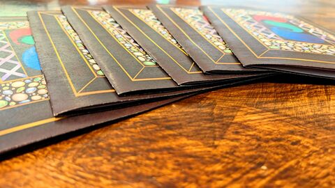 Close up of a set of closed copies of the zines on a wood table.