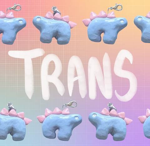 Alternating stegosaurus charms arranged in two rows on the top and bottom of the image. Both charms are pastel blue with light pink back plates and white eyes. "Trans" is handwritten in white between the two rows. The background is an unevenly faded white grid overlaying a pastel rainbow gradient.